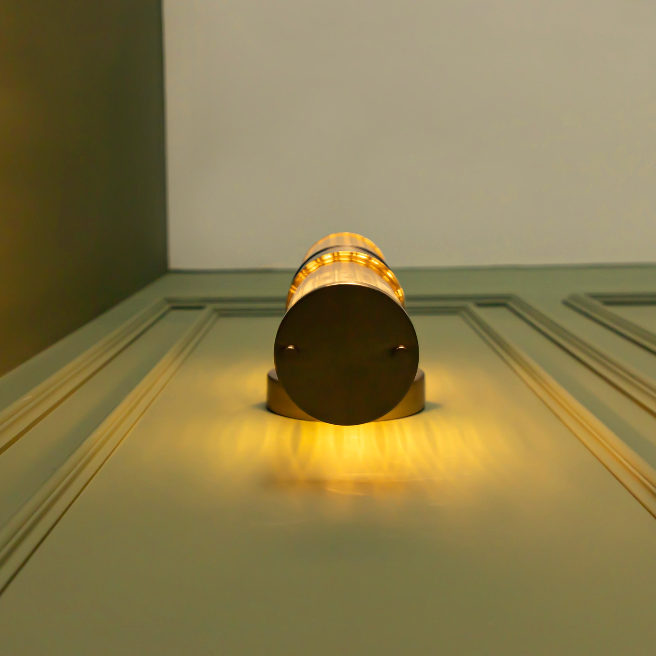 Decorative cylindrical light on a door with warm glow