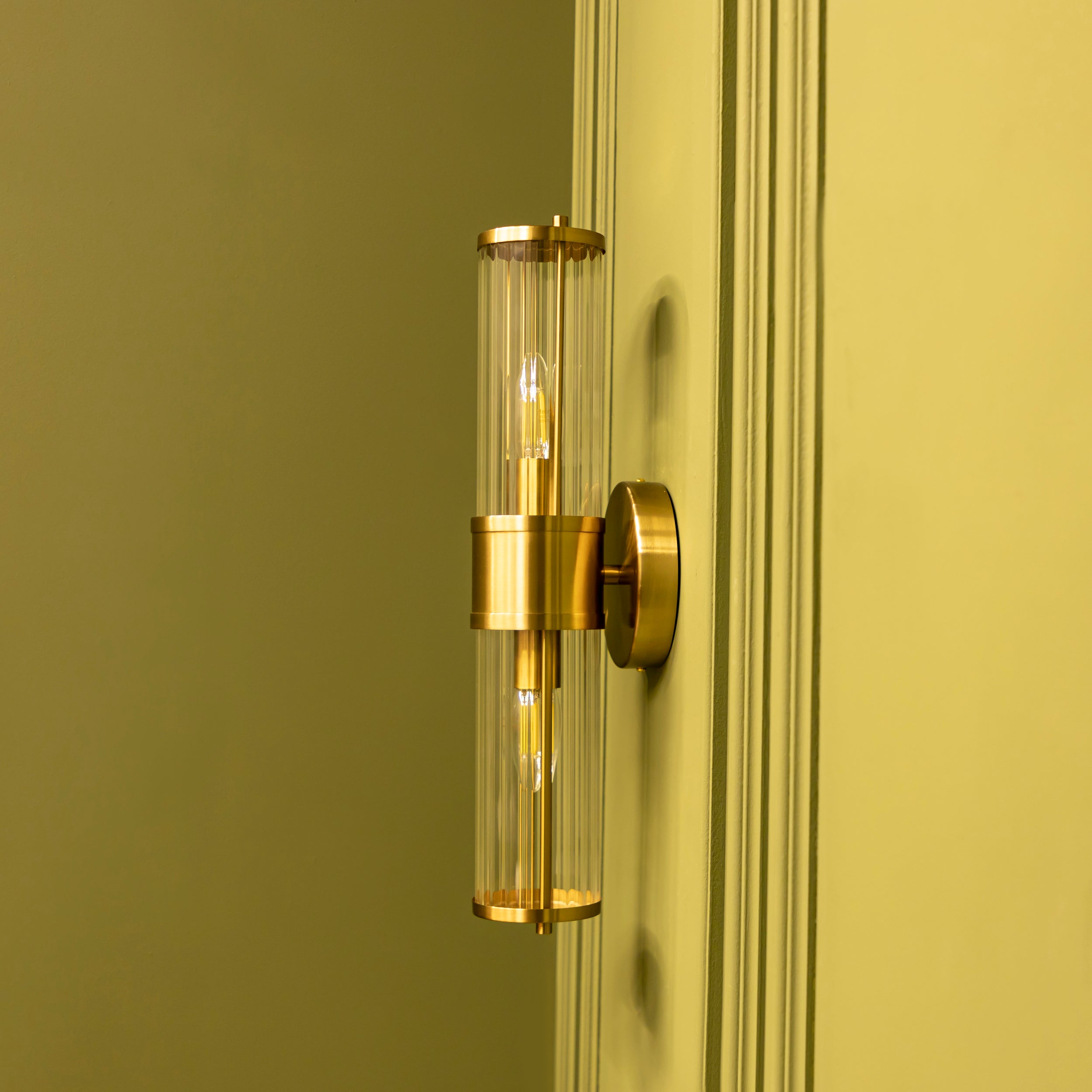 Gold wall sconce on a green wall