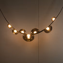 Modern chandelier with gold spherical lights on a neutral background