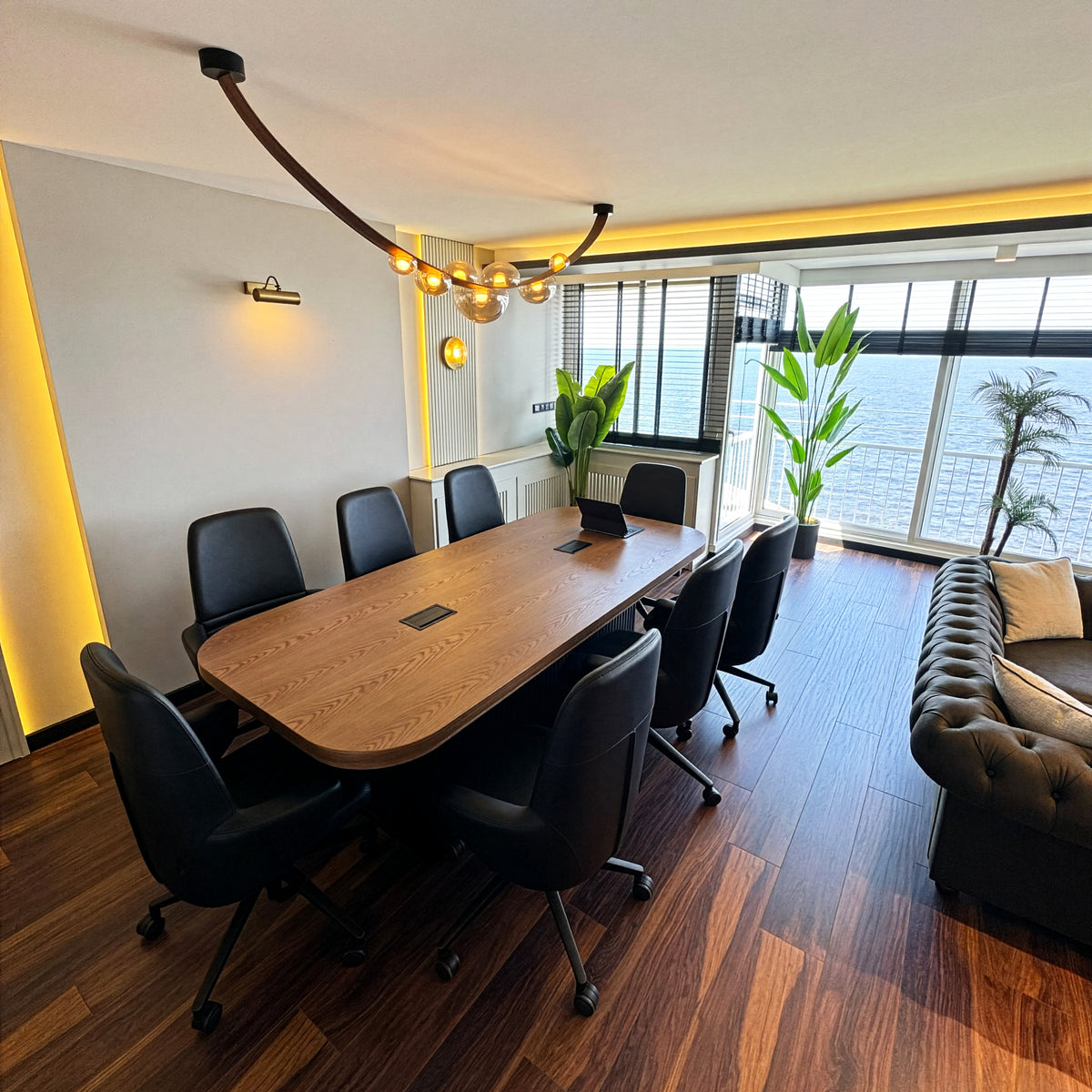 Modern conference room with a long wooden table, chairs, and a large window.
