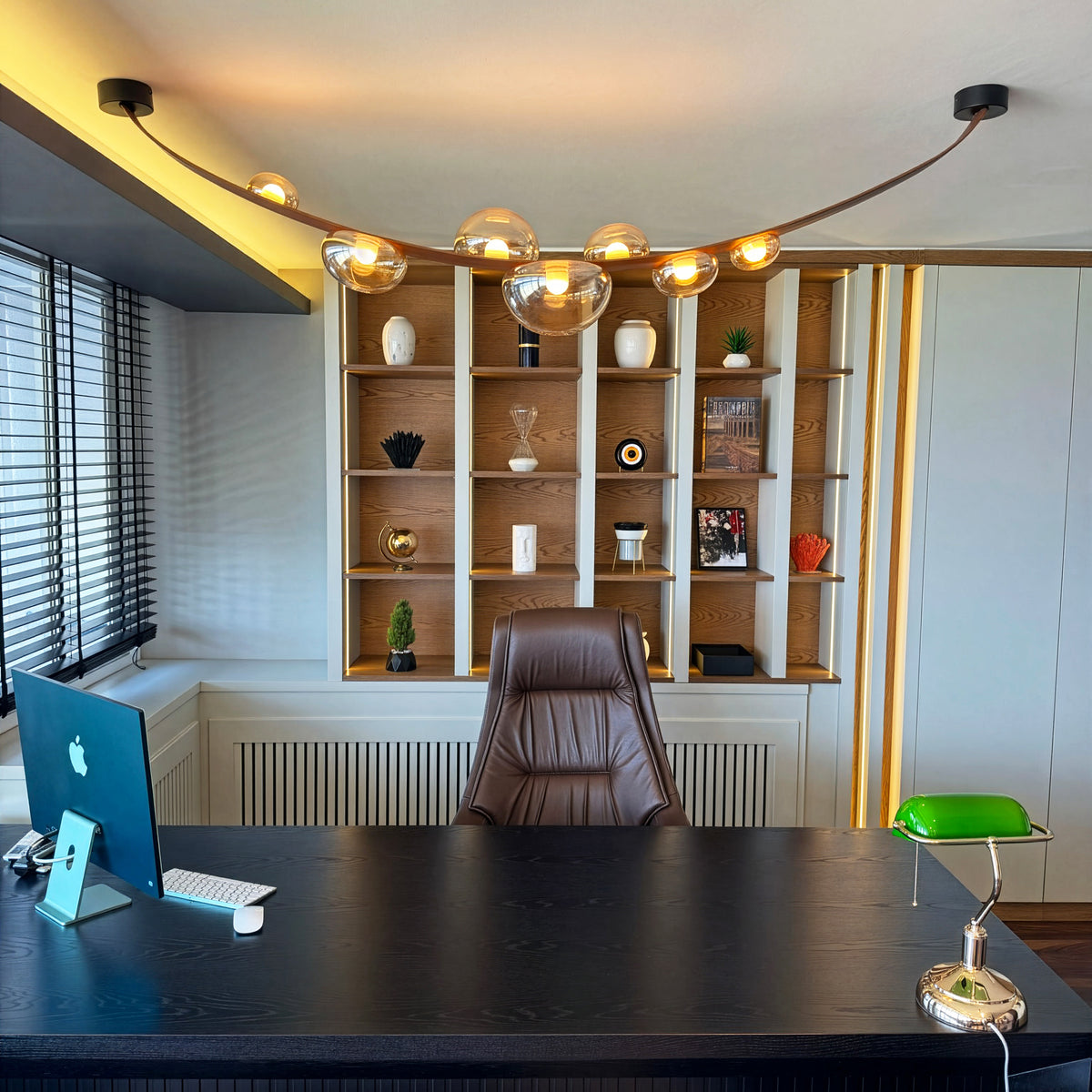Modern office setup with a desk, chair, and bookshelf.